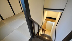 Eine Holztreppe mit schwarzen Geländern und einer weißen Wand mit schwarzem Zierleisten.