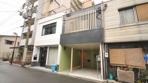 Eine Reihe mehrstöckiger Wohngebäude mit unterschiedlichen Architekturstilen, darunter eine moderne Fassade mit großen Fenstern und ein traditionelles Design mit Holzlamellen.