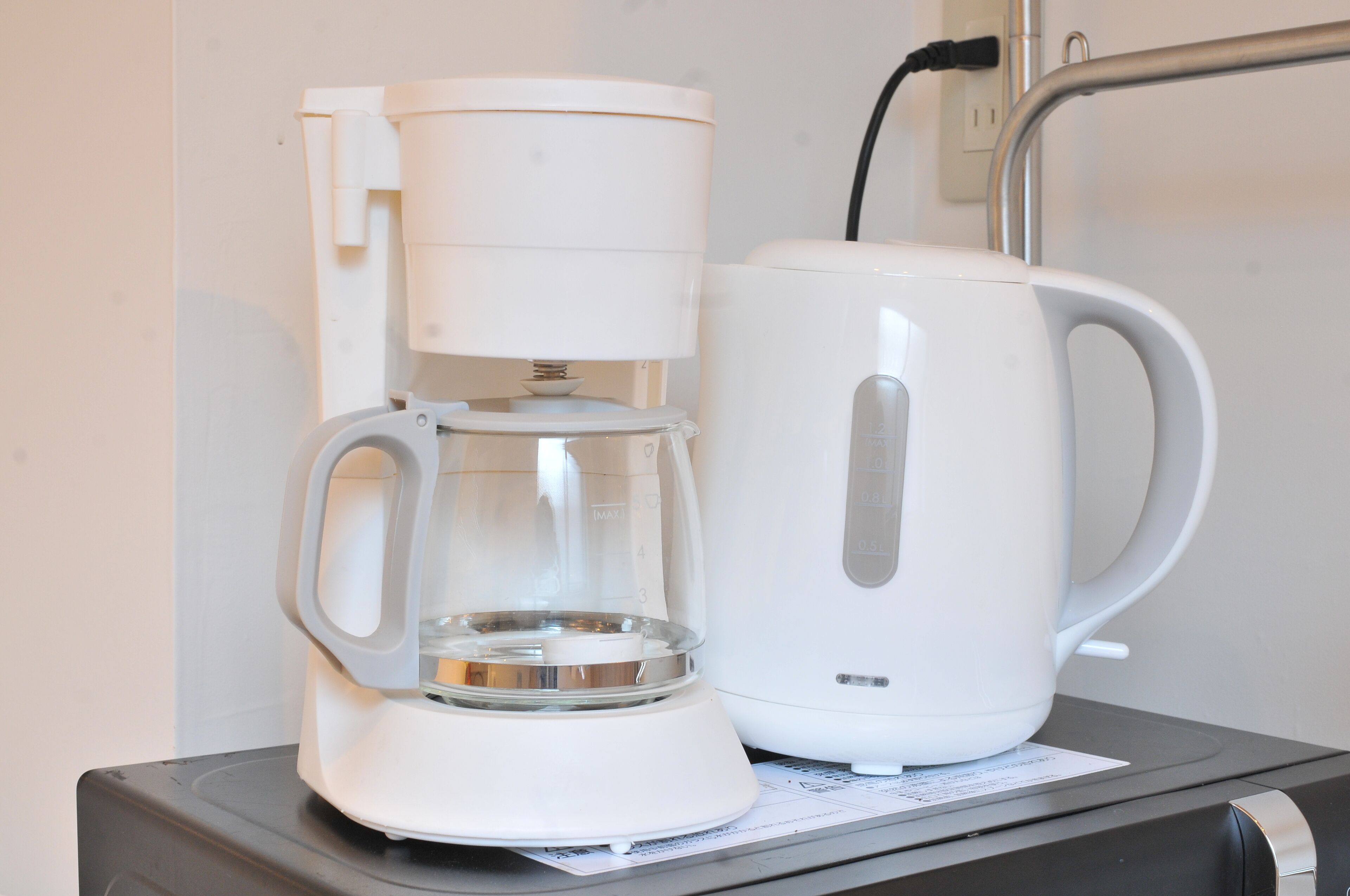 Uma cafeteira e uma chaleira sobre a mesa.