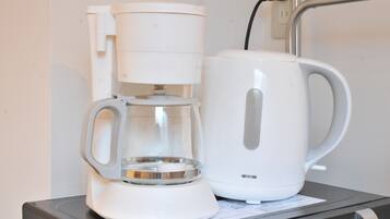 Uma cafeteira e uma chaleira sobre a mesa.