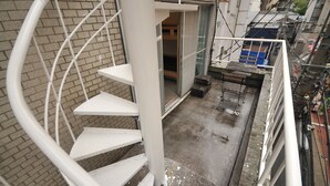 Un escalier en colimaçon mène à un balcon d’où l’on peut admirer un quartier résidentiel.