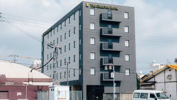 Un edificio moderno di un hotel con facciata piatta, diversi balconi e un cartello con la scritta "The Celestion Hotel".