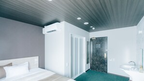 A modern hotel room with a large bed, a bathroom with a glass shower, and a small seating area. - The Celecton Kurashiki Mizushima (Kurashiki)