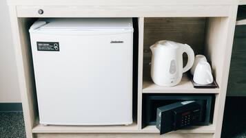 Una kitchenette equipada con refrigerador, cafetera y microondas.