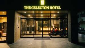 The exterior of The Cecilton Hotel with a neon sign, glass doors, and a motorcycle parked outside. - The Celecton Kurashiki Mizushima (Kurashiki)