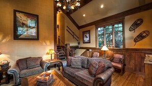 A cozy living room with a wooden staircase, patterned sofas, and a chandelier. - Old Town - Ski-In/Out - Super Luxurious 5BR/5BA - Hottub--Firepit - Ski Run View (Park City)