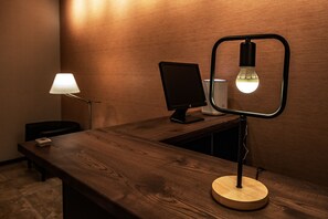 A wooden desk with a lamp and a monitor.
