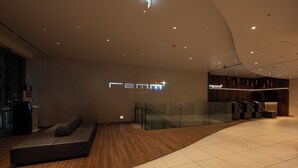 Un interior moderno con una mesa de recepción, una zona de estar y una escalera.