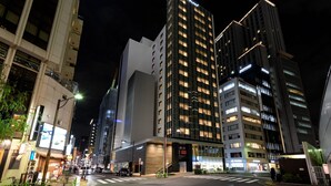 A modern urban street at night with illuminated buildings, a crosswalk, and a bicycle. - remm plus Ginza (Tokyo)