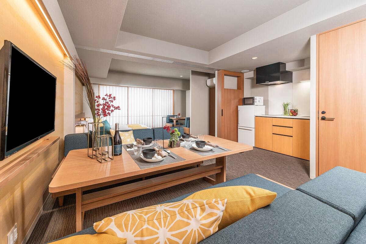 Un espace de vie moderne et compact comprenant un coin repas, une kitchenette et un coin salon.
