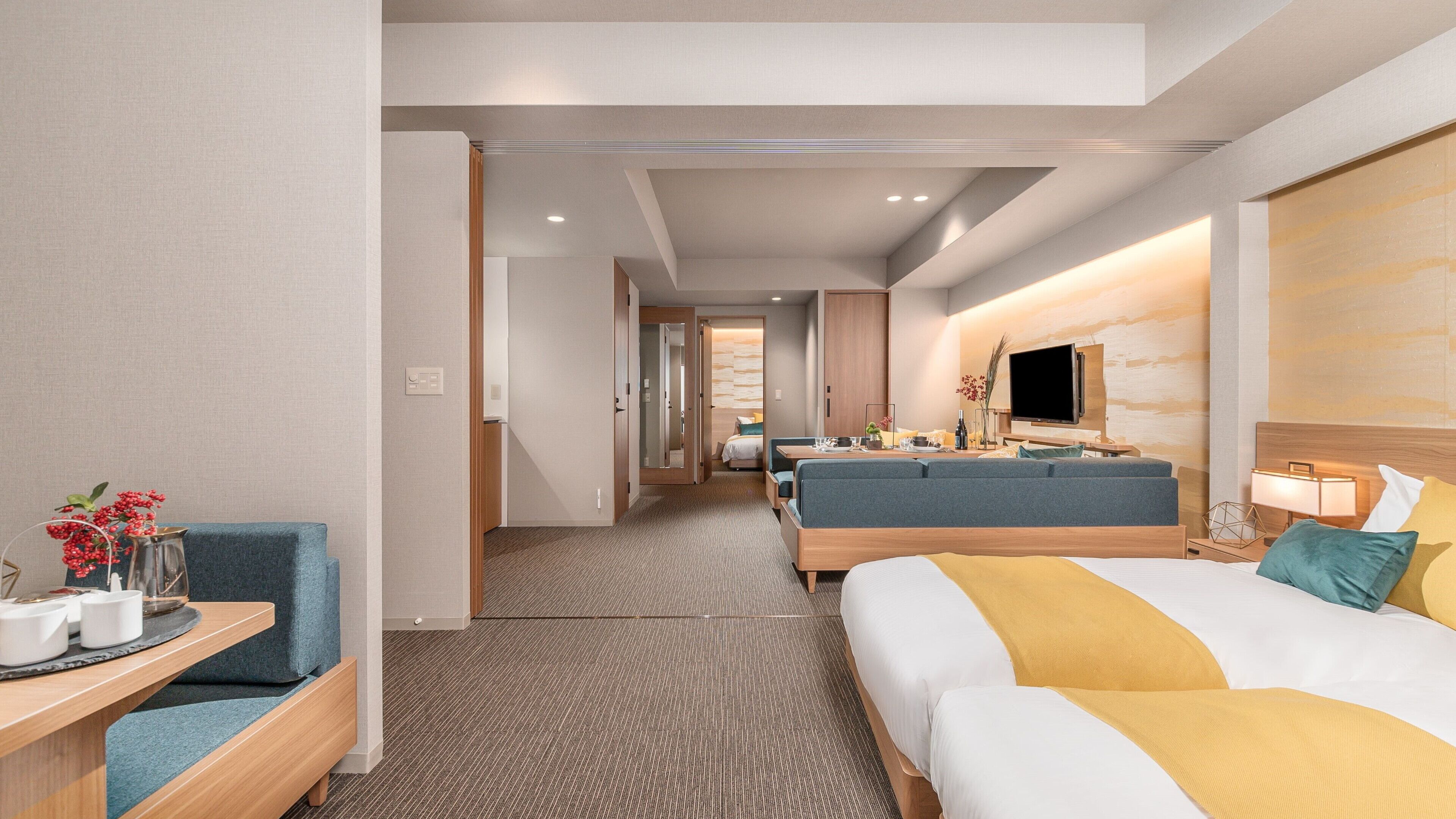 Una habitación de hotel con cama, sofá, escritorio y televisión.