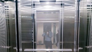 An elevator with metallic walls and a geometric floor pattern. - Hotel Khan Palace (Kalapara)