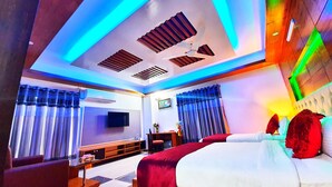 A modern hotel room with a large bed, a desk, and a TV. - Hotel Khan Palace (Kalapara)