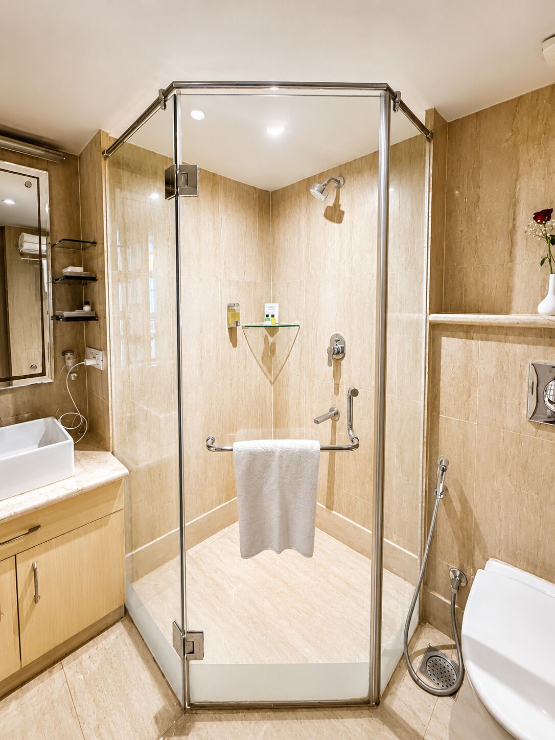 A modern bathroom with a glass-enclosed shower, a sink, and a toilet.