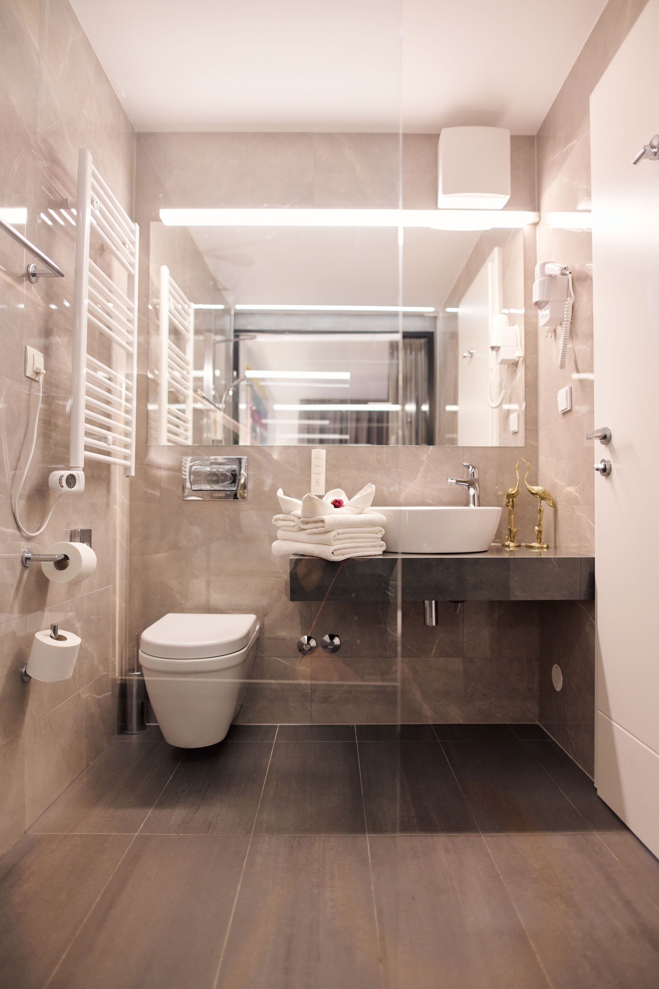 Une salle de bain moderne équipée de toilettes, d’un lavabo et d’une douche.