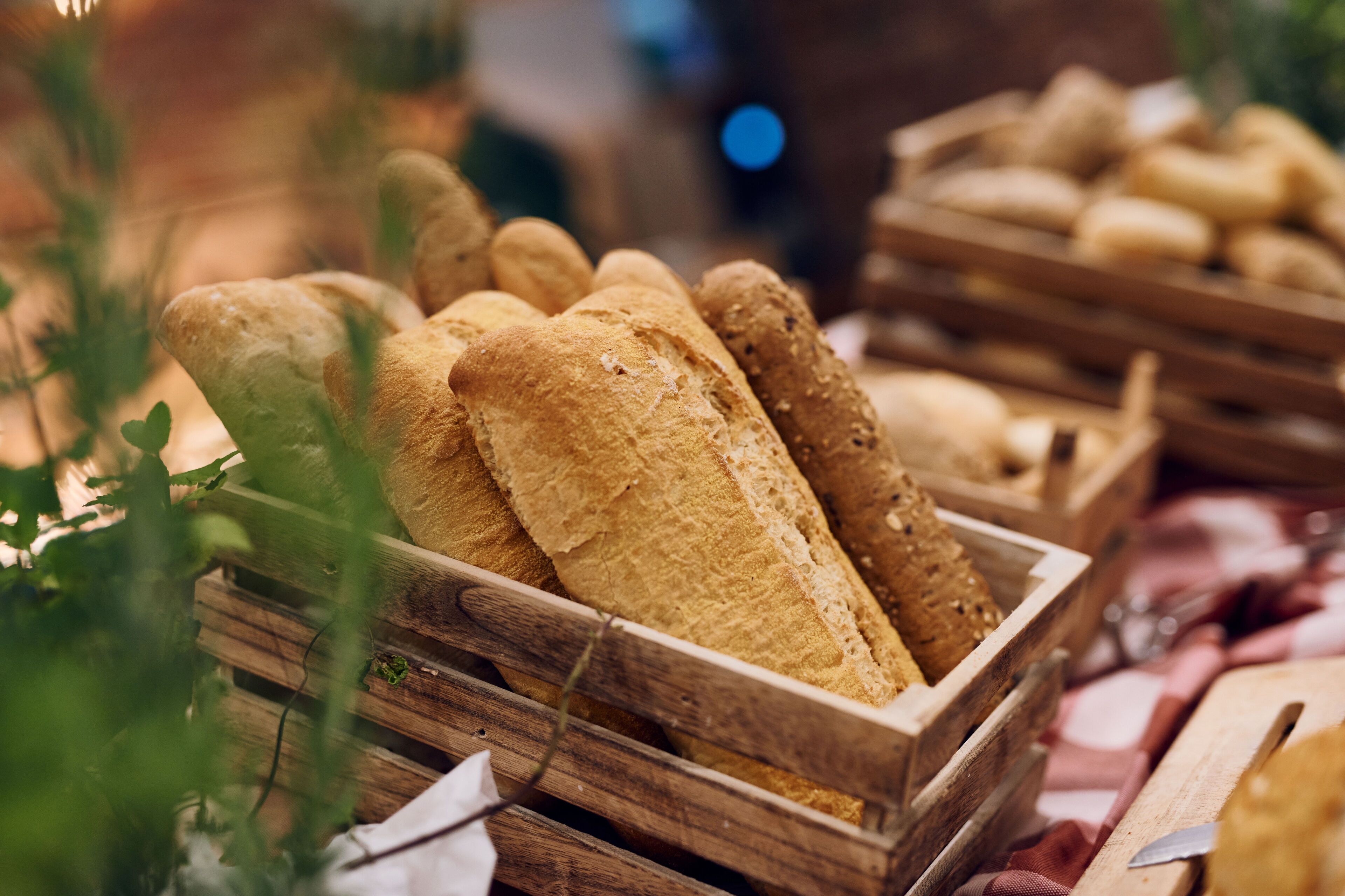 A wooden crate filled with various types of bread.