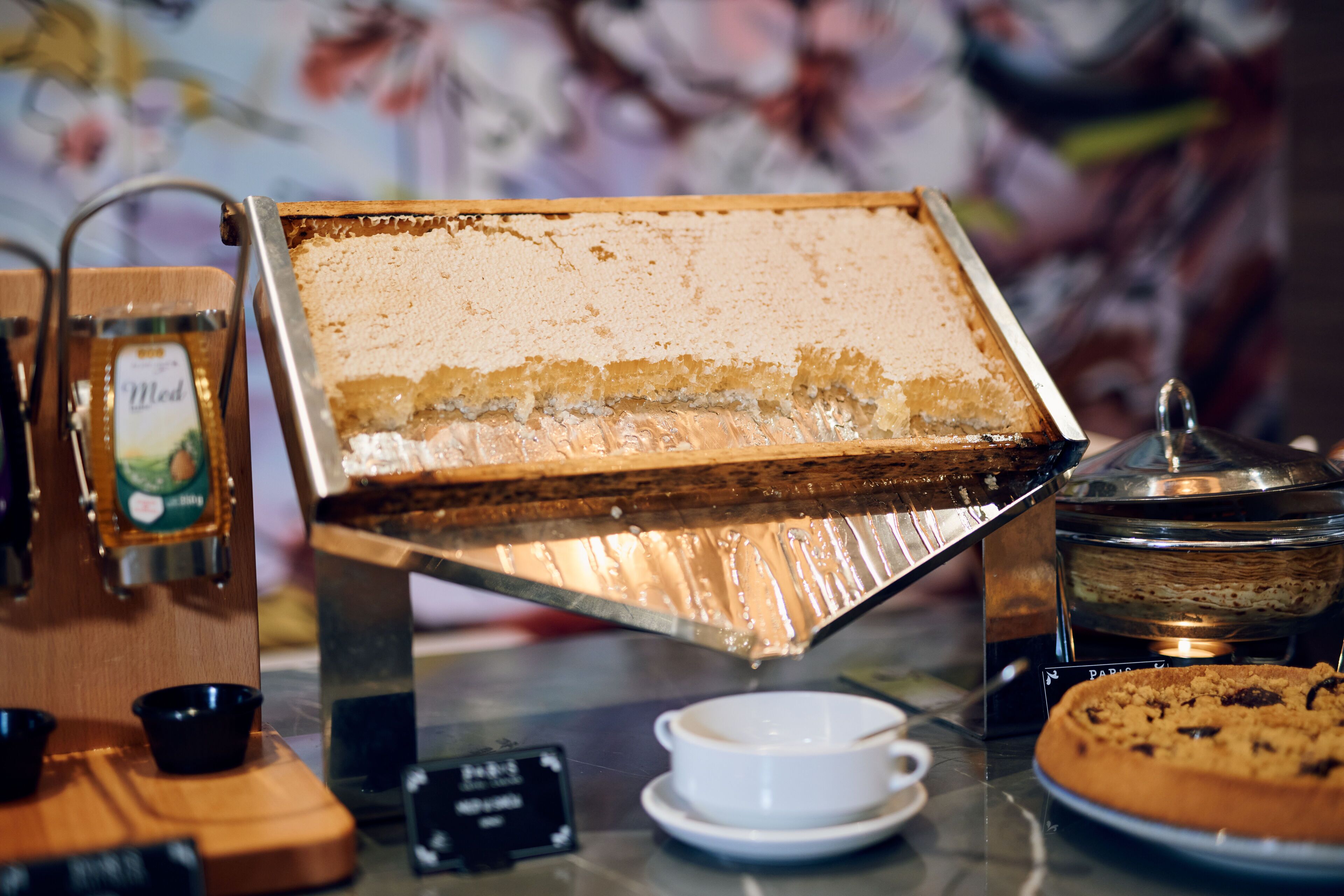 A coffee machine with a milk frother and a cup of coffee on a table.