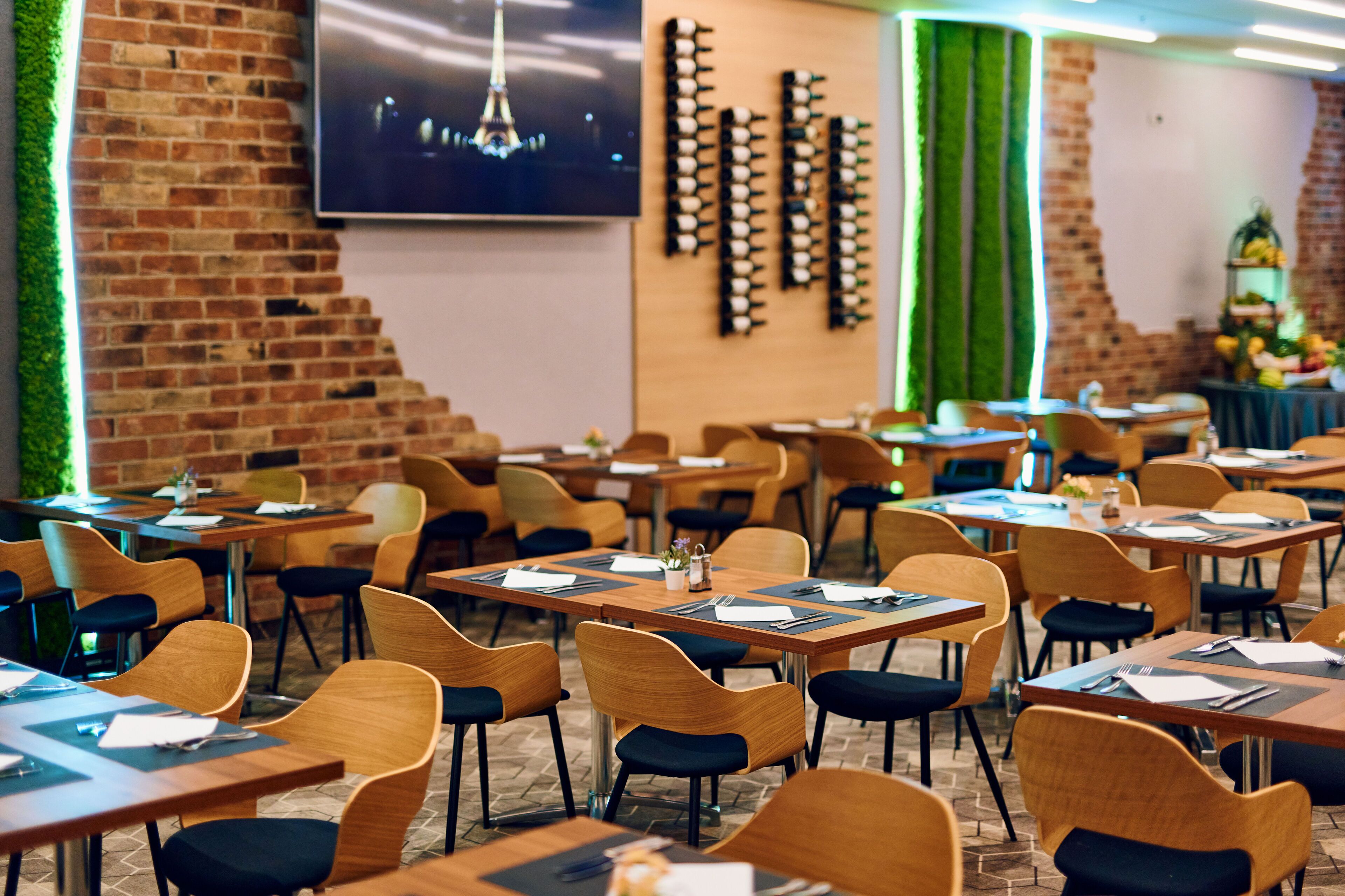 A restaurant with brick walls, wooden tables, and chairs.