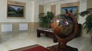 En lobby med et verdenskort, malerier, en radiator og en plante.