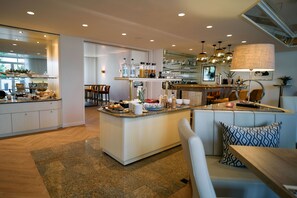 Une cuisine moderne dotée d’un îlot central, d’un coin bar, de sièges et d’un espace repas.