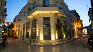 A corner building with a balcony, large windows, and a door.