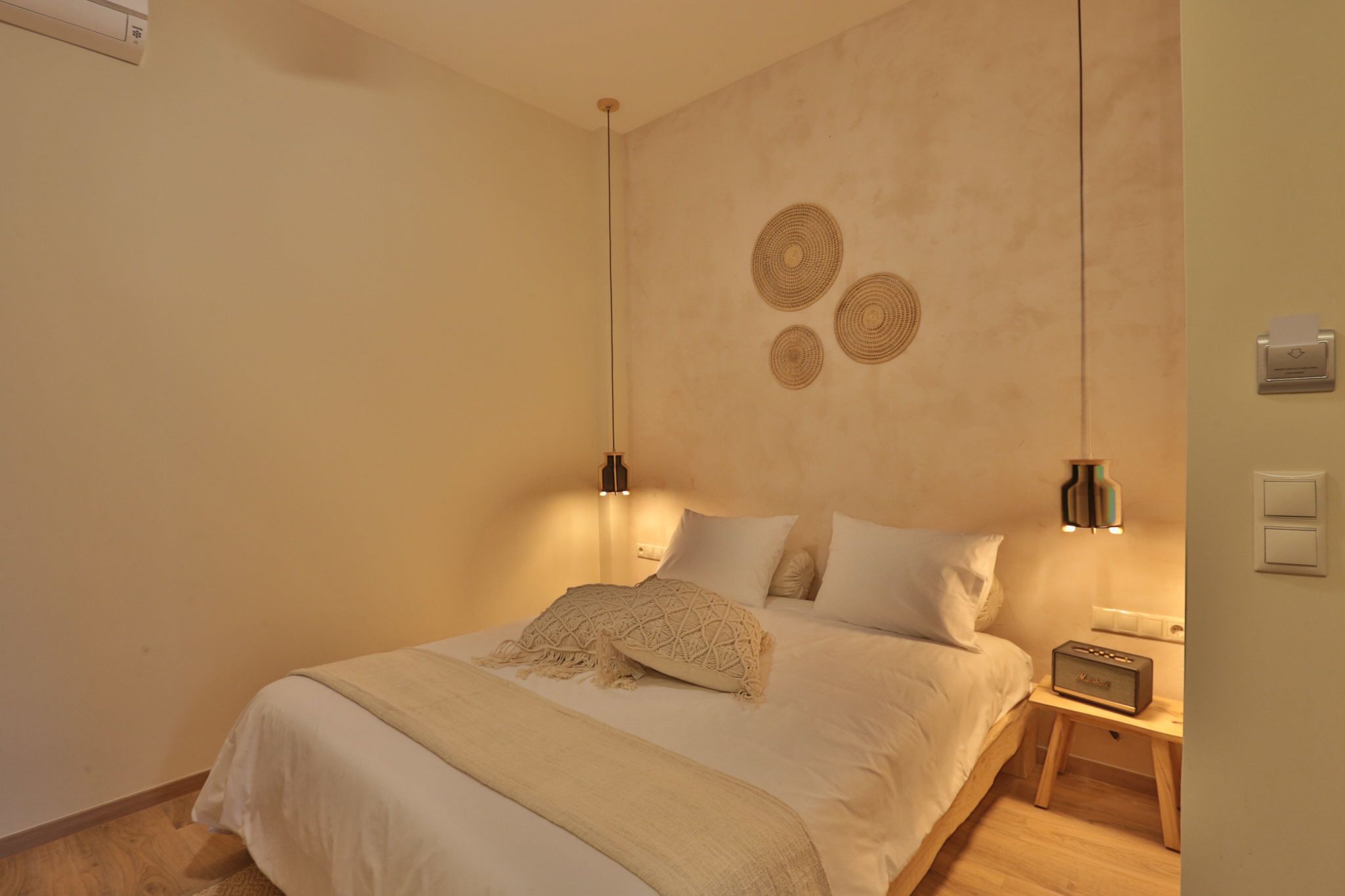Une chambre à coucher comprenant un lit, des lampes de chevet, une table de chevet et des éléments de décoration murale.