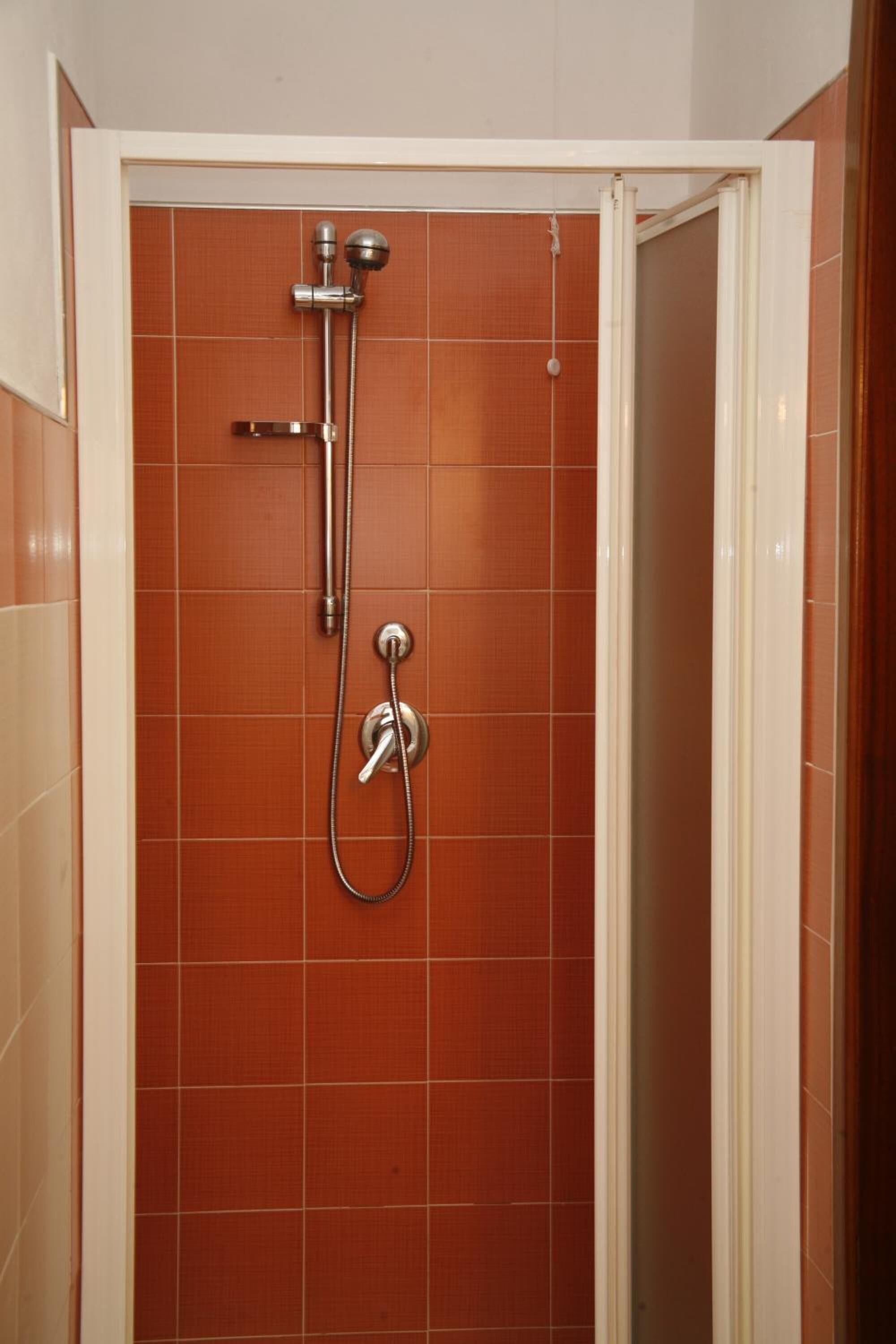 Ducha con cabezal de ducha de mano y grifo empotrado.