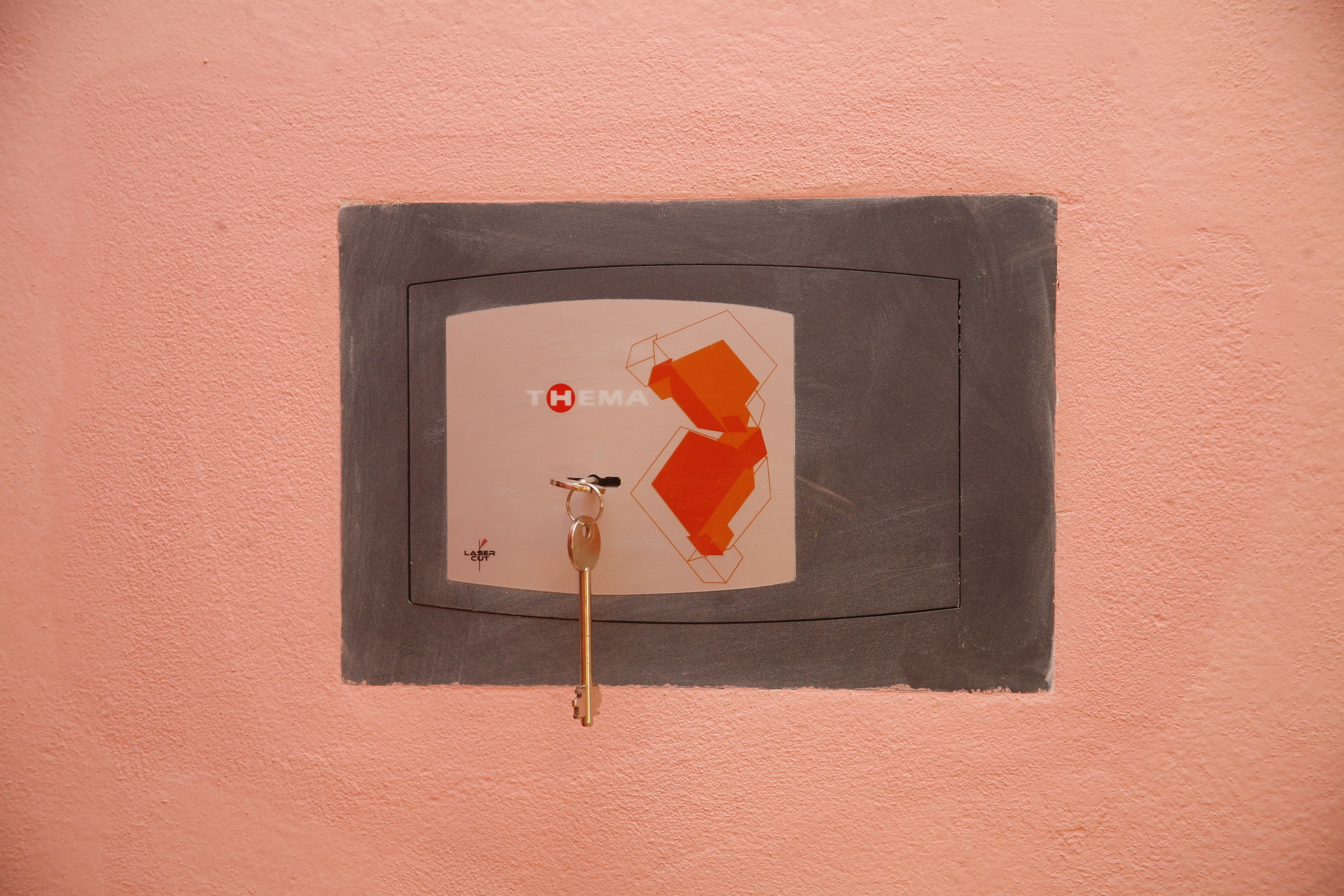 A wall-mounted key holder with a key and a padlock.