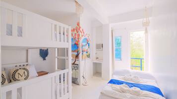 A bright, white room with a bed, a crib, and a colorful mural.
