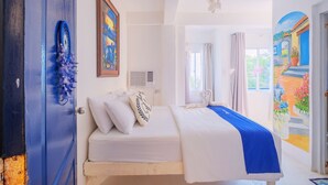 Un dormitorio con cama, un cuadro en la pared, una lámpara en el techo y vistas al exterior.