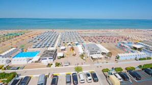 A beach resort with multiple swimming pools, a restaurant, and a parking area.