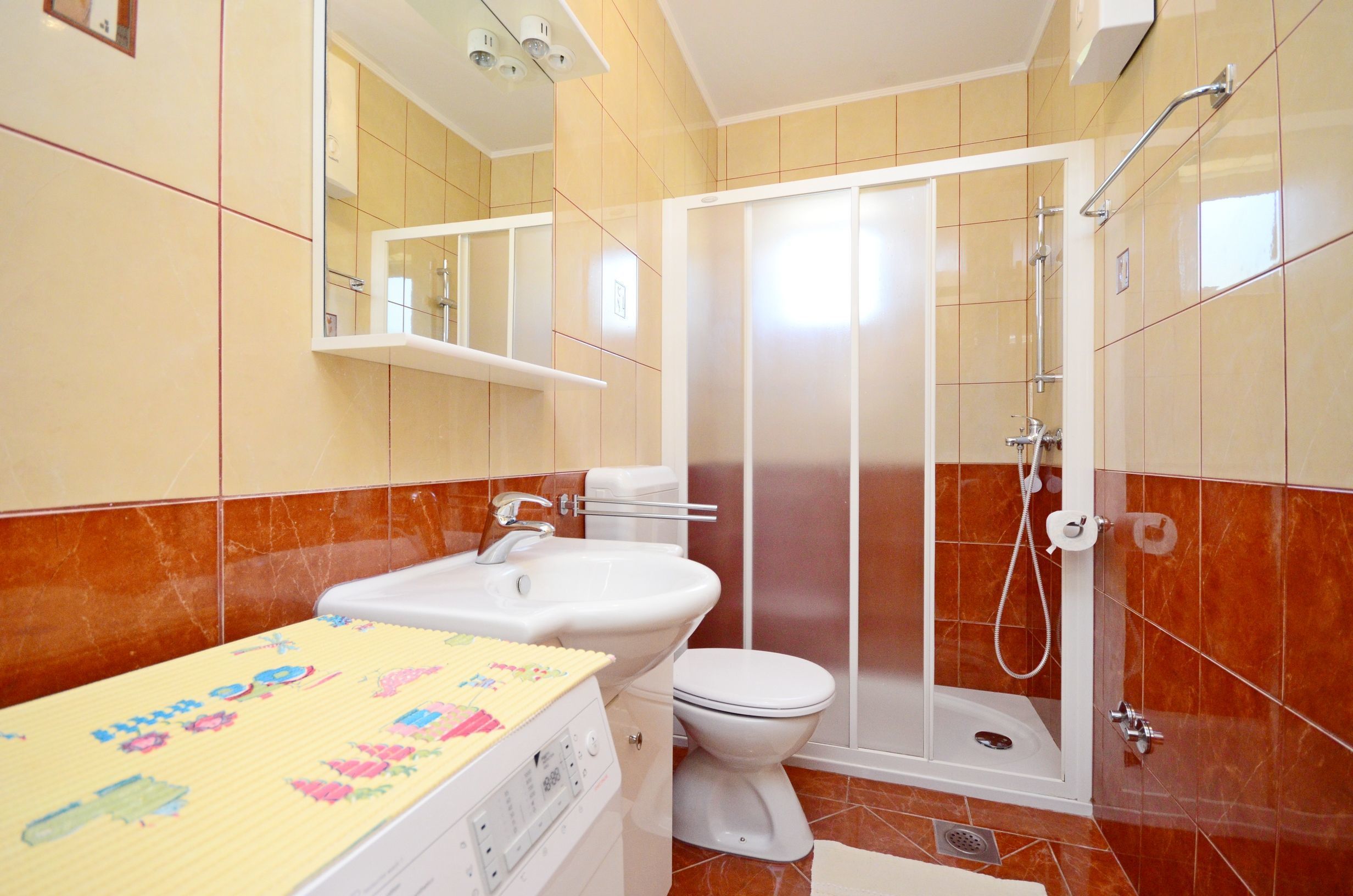 Une salle de bain avec des toilettes, un lavabo et une douche.