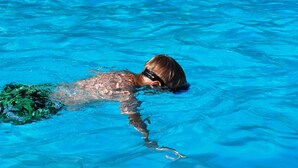 Une personne qui nage dans une piscine.