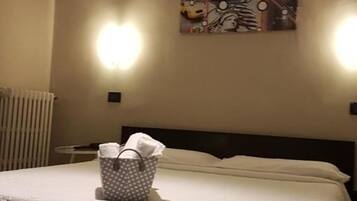 Une chambre d’hôtel avec un lit, une œuvre d’art accrochée au mur et deux appliques murales.