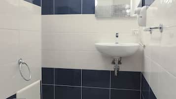 A bathroom with a bidet, sink, and mirror.