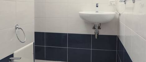 A bathroom with a bidet, sink, and mirror.