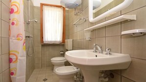 A bathroom with a shower, toilet, bidet, and sink. - Appartamenti dei Fiori (Lignano Sabbiadoro)