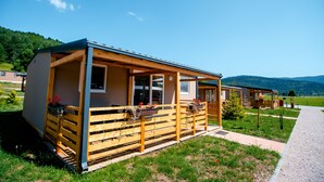 Eine Holzhütte mit Veranda, Fenstern und Blumenkästen.
