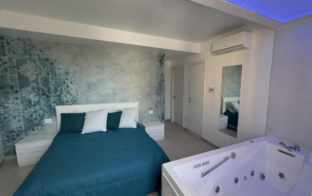 Un dormitorio moderno con una cama grande, una bañera integrada y un equipo de aire acondicionado instalado en la pared.