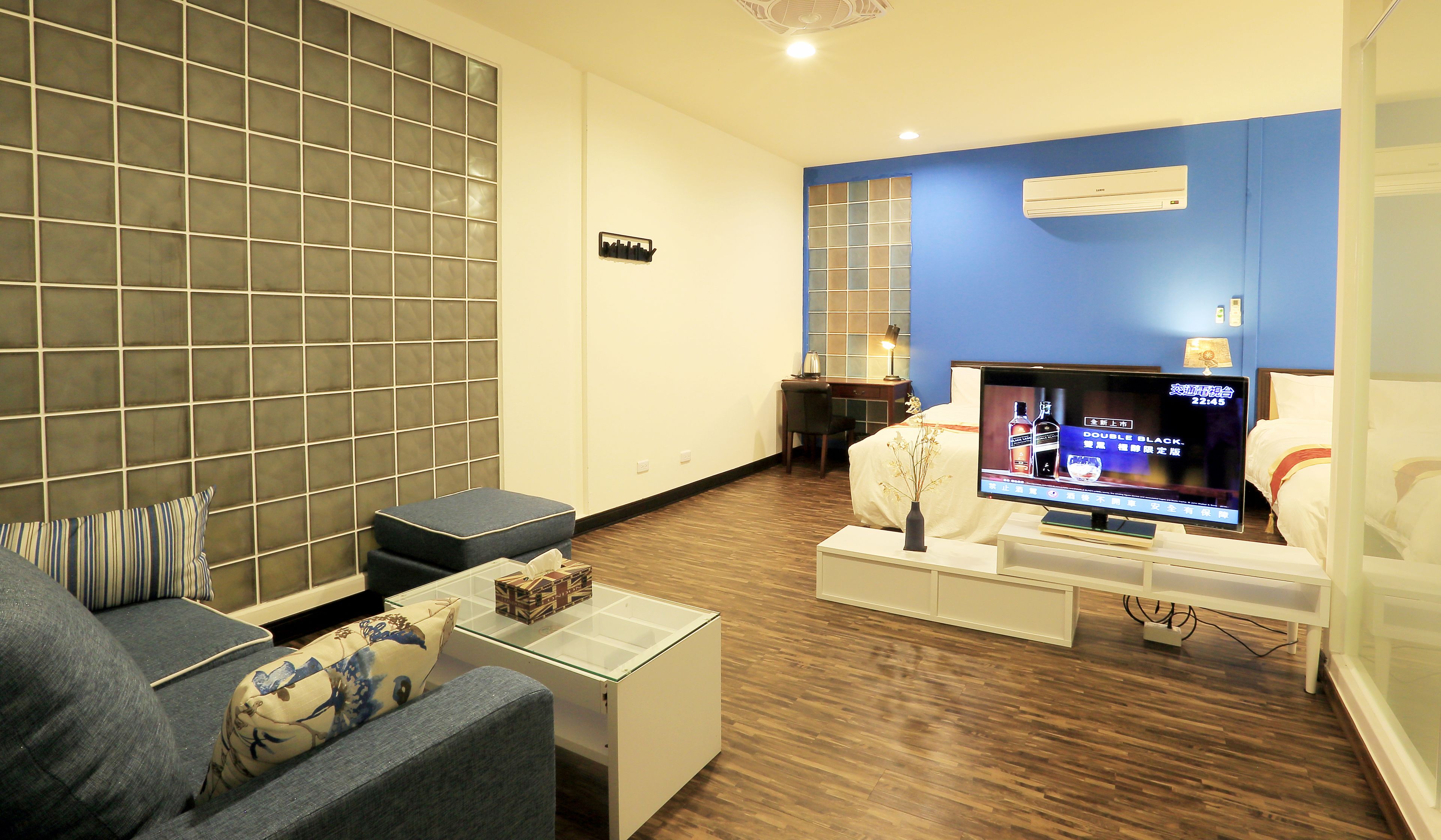 A modern living room with a flat-screen TV, a sofa, a coffee table, and a small side table.