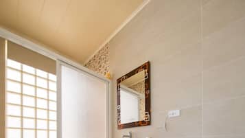 Habitación cuádruple Deluxe | Baño | Ducha, artículos de higiene personal gratuitos, zapatillas y toallas