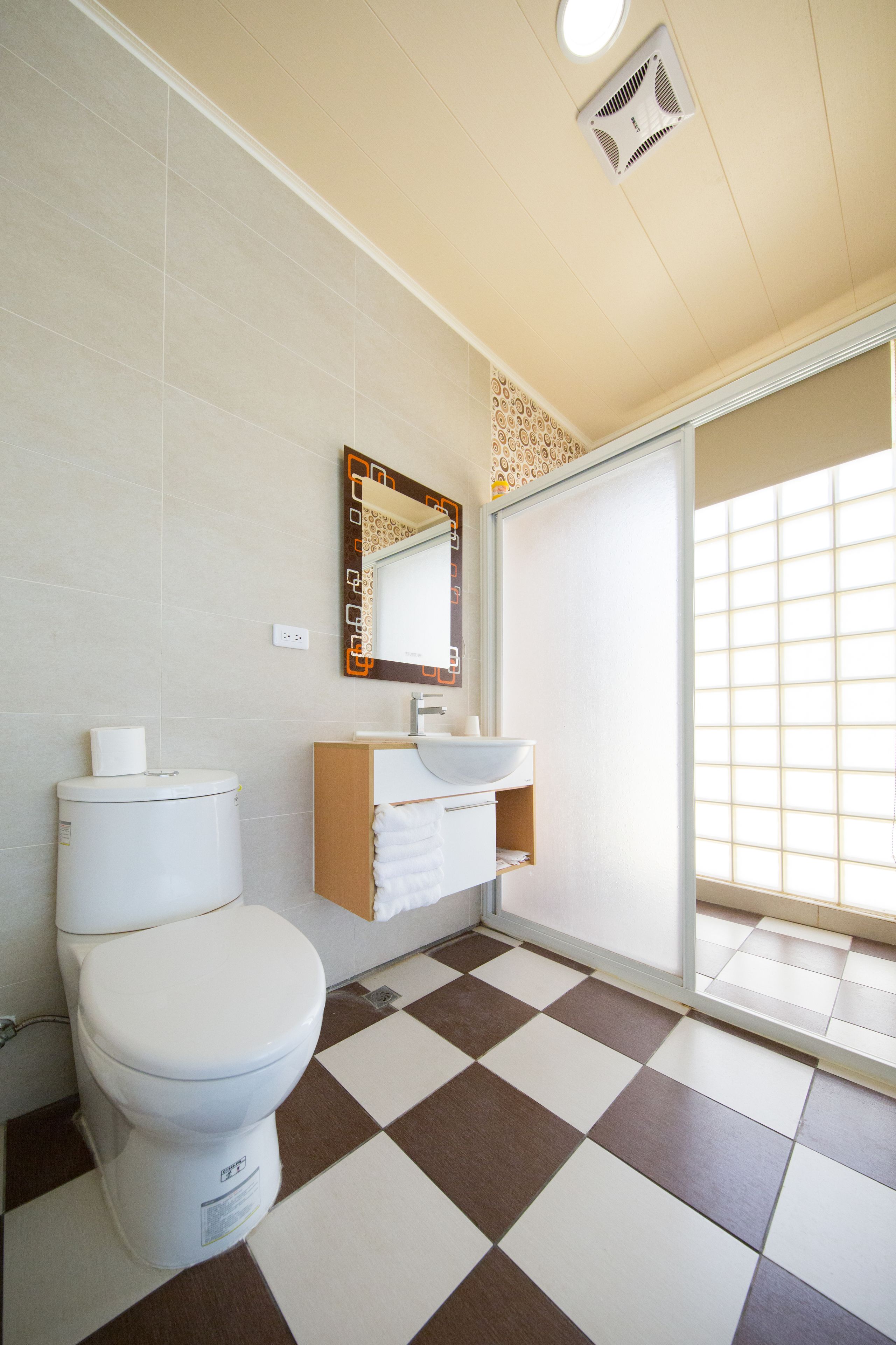 Une salle de bain avec des toilettes, un lavabo et un miroir.
