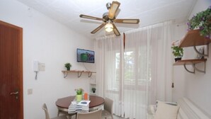 Un espace repas comprenant une table ronde, des chaises, un ventilateur de plafond et un canapé.
