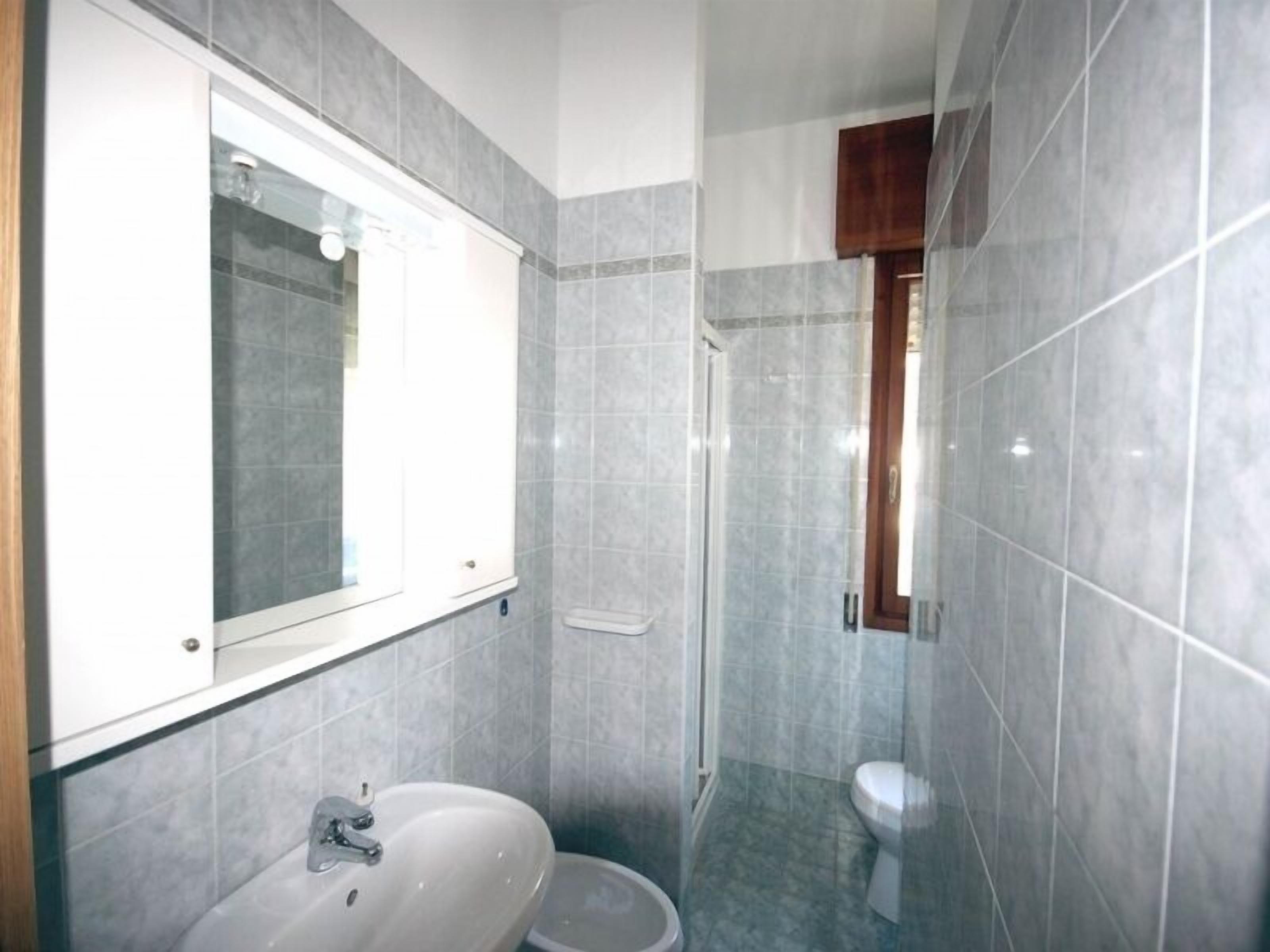 Een badkamer met een wastafel, spiegel en toilet.
