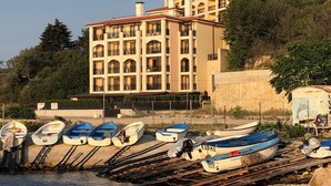 A building with multiple balconies and a row of boats docked in front. - Sunny Suites by Casa Del Mare (Varna)