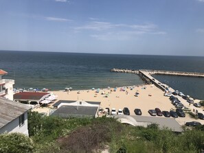 A beach with umbrellas, a pier, and parked cars. - Sunny Suites by Casa Del Mare (Varna)
