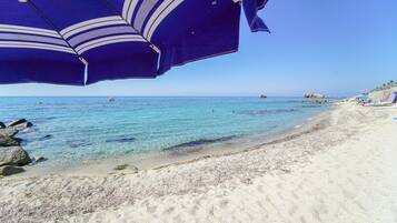 Pantai pribadi di sekitar, pasir putih, dan kursi berjemur