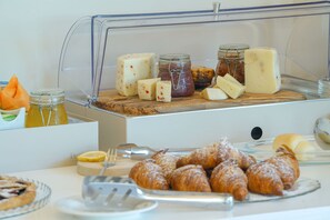 Ein Buffet mit verschiedenen Käsesorten, Gebäck und Beilagen.