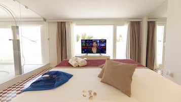 Ein Hotelzimmer mit einem großen Bett, einem Fernseher und Blick auf Palmen.