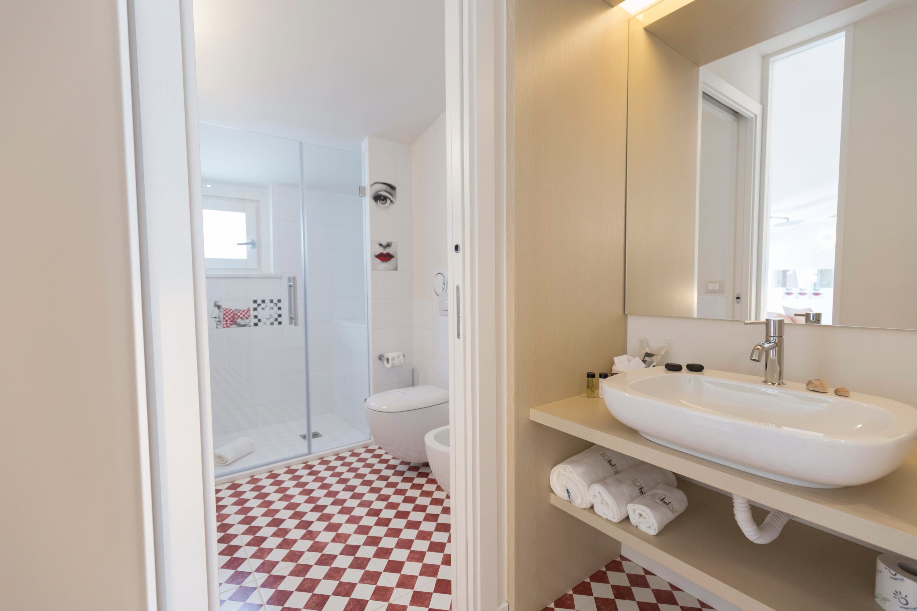 Ein Badezimmer mit Schachbrettboden, einem weißen Waschbecken und einem Spiegel darüber.